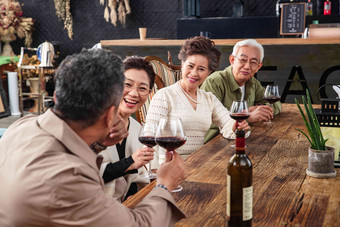 快乐的中老年朋友们品尝红酒餐桌清晰图片