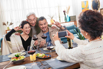 聚餐时中老年人用手机拍照举杯清晰照片