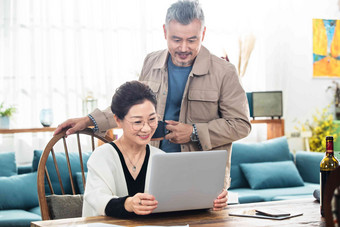 幸福的中老年夫妇在家使用笔记本电脑