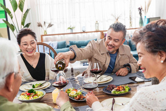 <strong>聚餐</strong>时中年男士给朋友倒红酒中老年女人高端拍摄