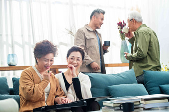 中老年人们在客厅喝茶聊天看相册叙旧