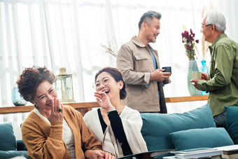 退休的中老年人在居室喝茶聊天看相册