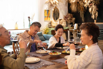 幸福的两对中老年夫妻在家一起烛光聚餐