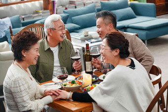 快乐的中老年朋友边吃饭边聊天老年夫妇摄影图