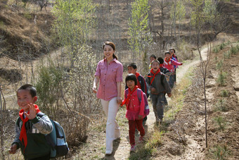 乡村老师和学生走在山路上