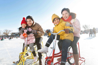 快乐的一家四口在滑冰场玩耍厚衣服高清场景