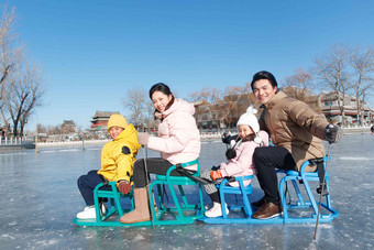 快乐的一家人坐冰车玩耍青年夫妇清晰场景