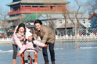 快乐的一家三口坐冰车玩耍中国人高端图片