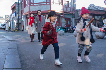 拿着糖葫芦的小朋友和父母<strong>逛街</strong>青年女人清晰照片