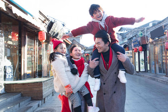 青年夫妇带着孩子逛街购物中国人高端场景