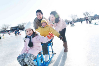 快乐的一家四口坐冰车玩耍湖高质量相片