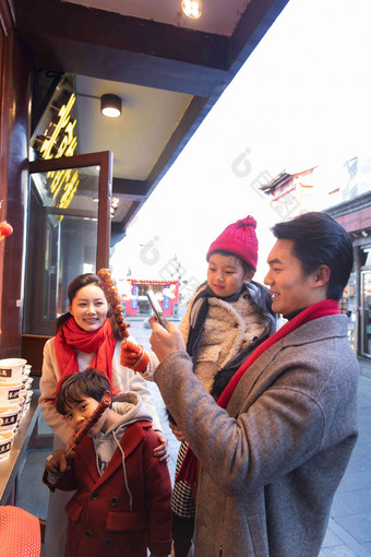 快乐的一家人买糖葫芦手机支付清晰图片