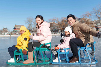 坐冰车玩耍的一家四口女孩素材