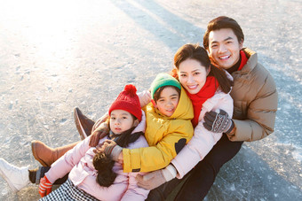 快乐的一家四口坐在冰面上玩耍人高质量摄影图