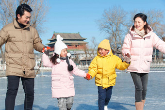 手牵手滑冰的快乐家庭人高质量摄影图