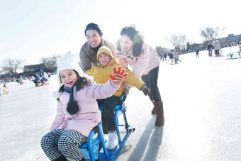 快乐的一家四口坐冰车玩耍冰车素材