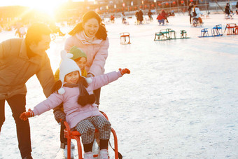 快乐的一家三口坐冰车玩耍中国氛围相片