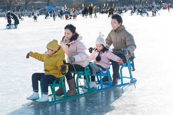 快乐的一家四口坐冰车玩耍女孩写实摄影
