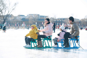 坐冰车玩耍的一家四口幸福氛围照片
