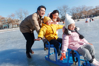 快乐的一家四口坐冰车玩耍东方人氛围照片