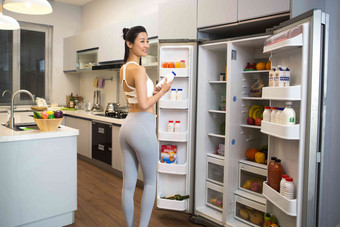穿着运动装的青年女人在厨房水平构图氛围图片