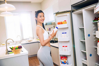 穿着运动装的青年<strong>女人</strong>在厨房住房摄影