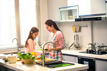 年轻妈妈和女儿在厨房厨房器具高端摄影图