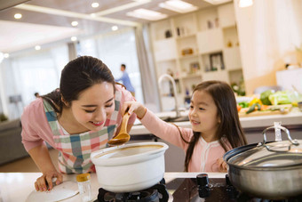 年轻妈妈和女儿在厨房生活方式清晰场景