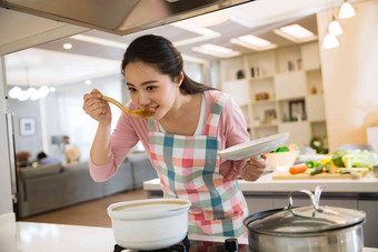 青年女人在厨房煲汤放松场景