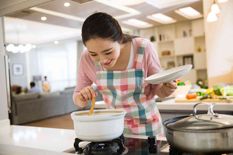 青年女人在厨房煲汤休闲装摄影图