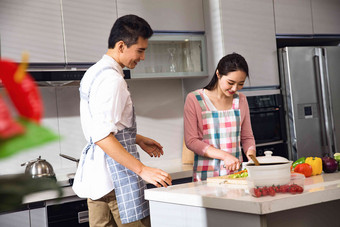 年轻夫妇在厨房做饭高端照片