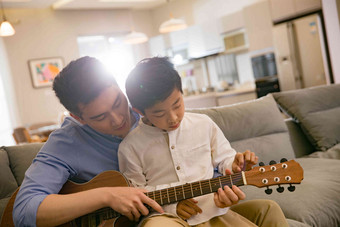 父亲和男孩在弹吉他住宅内部写实素材