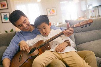 父亲和男孩在弹吉他童年场景