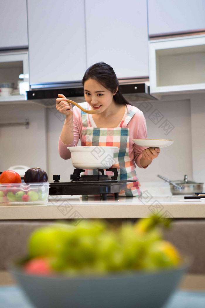 青年女人在厨房煲汤享乐相片 厨房做饭