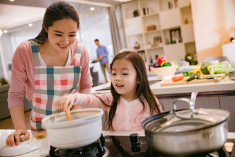 年轻妈妈和女儿在厨房快乐氛围摄影图