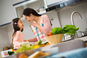 年轻妈妈和女儿在厨房快乐高清影相