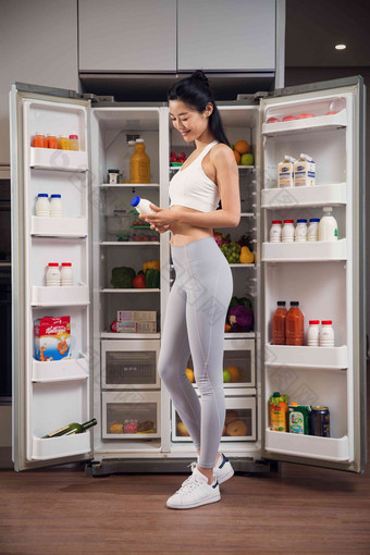 穿着运动装的青年女人站在冰箱前亚洲人相片