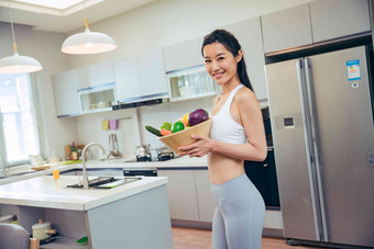 穿着运动装的青年女人在厨房快乐氛围摄影