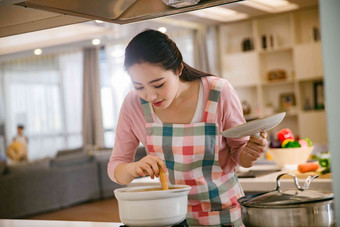 青年女人在厨房煲汤享乐高端镜头