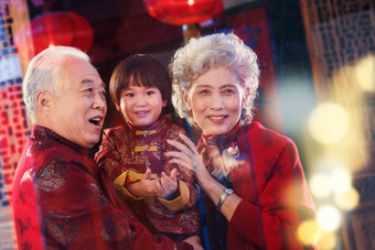 快乐的祖父母抱着孙子微笑氛围照片