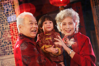 快乐的祖父母抱着孙子面部表情氛围相片