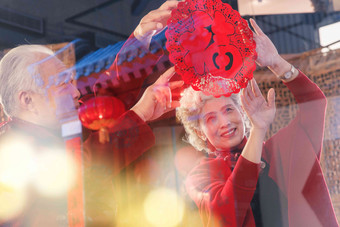 中国老年夫妇贴窗花表现积极高清照片