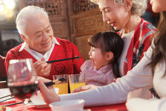 餐桌上祖父喂孙女吃饭