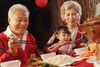 幸福的祖父母和孙女用餐