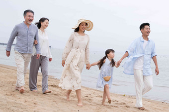 快乐的一家人在海滩上散步女人高端摄影图