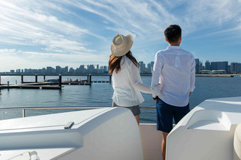 浪漫的青年夫妇站在游艇甲板上