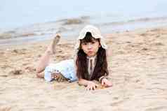 趴在海滩上玩耍的小女孩