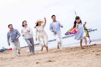 快乐的一家人在海滩上放风筝