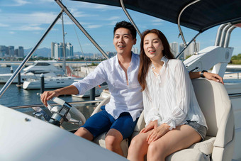浪漫的青年夫妇驾驶游艇出海