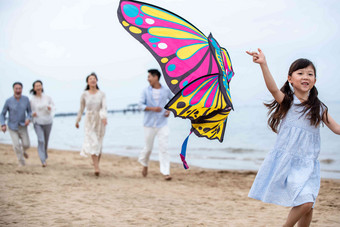 快乐的一家人在海滩上放风筝放风筝高质量图片